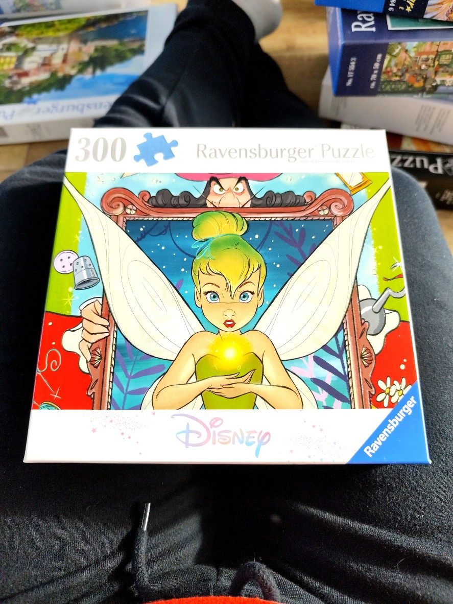 Illustration of Tinker Bell in a mirror frame with Captain Hook's eyes peeking over the top.