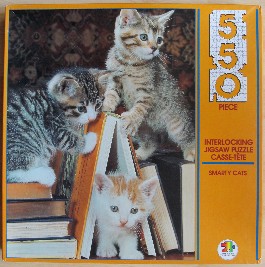 Three kittens playing with and sitting among a stack of vintage books