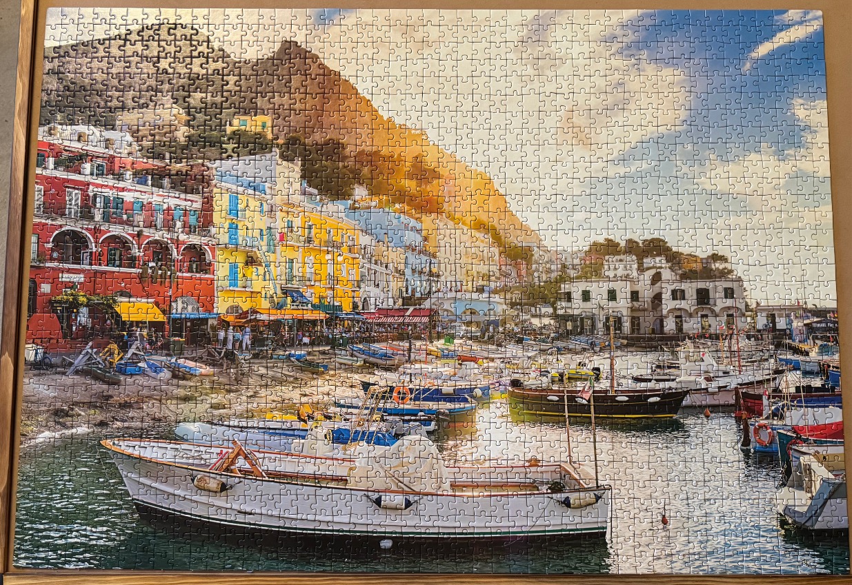 A scenic view of colorful buildings and fishing boats at the harbor in Marina Grande, Capri, Italy.