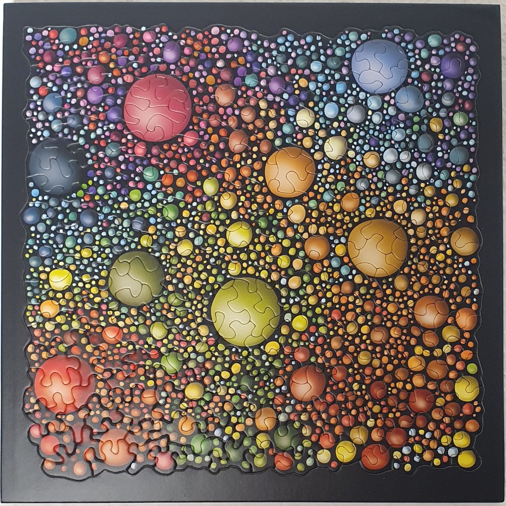 Abstract illustration of numerous multicolored spheres of varying sizes against a solid black background.
