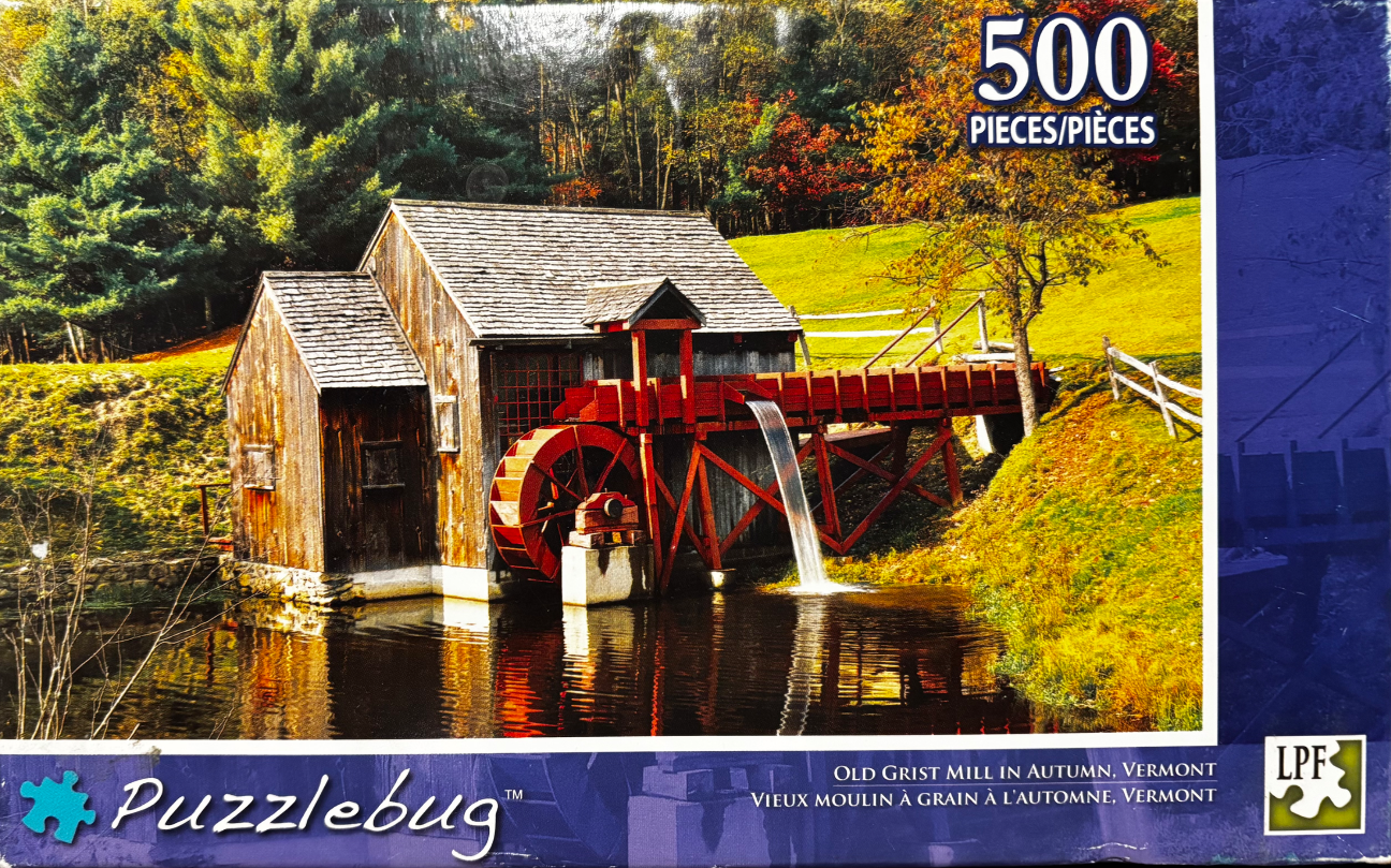 An old wooden grist mill with a red water wheel sits by a pond in a vibrant autumn forest setting.