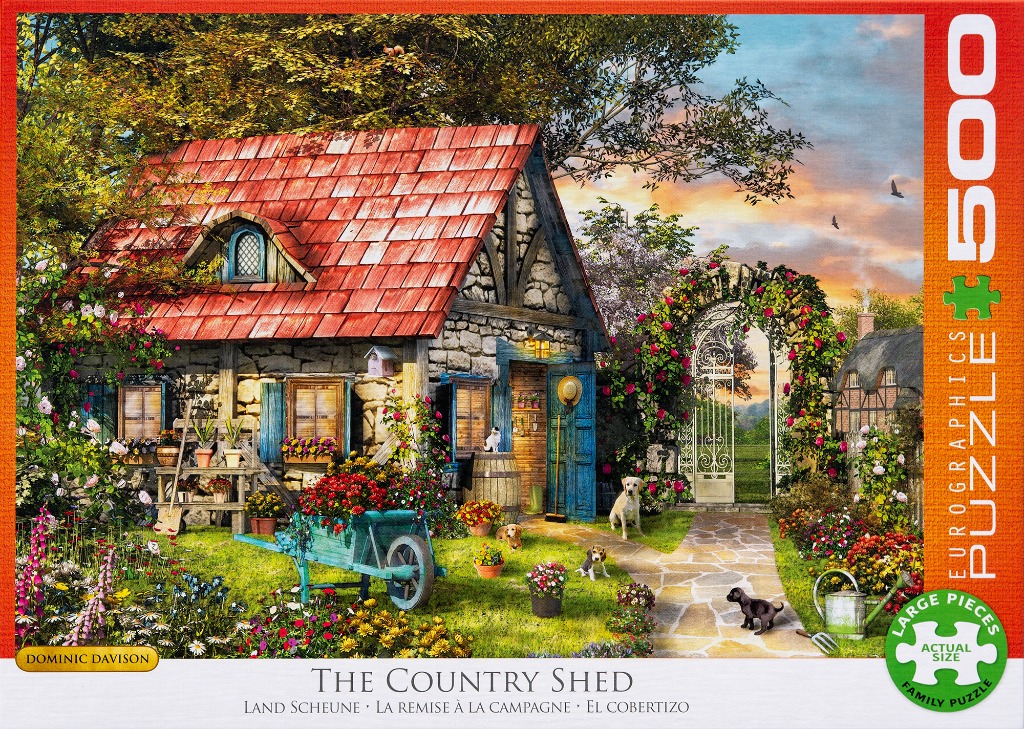 A stone cottage with a red roof, a garden filled with flowers, and several dogs playing on the grass.