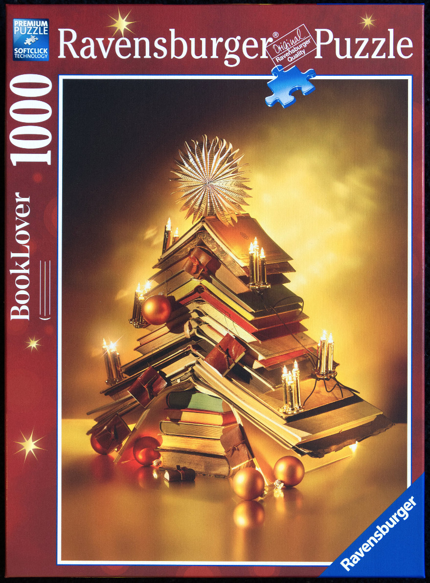 A Christmas tree shaped sculpture made of stacked vintage books, adorned with candles and ornaments.