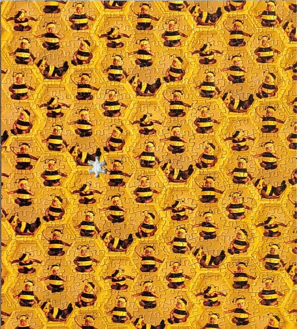 A repeating pattern of babies in bumblebee costumes nestled inside a yellow honeycomb grid.