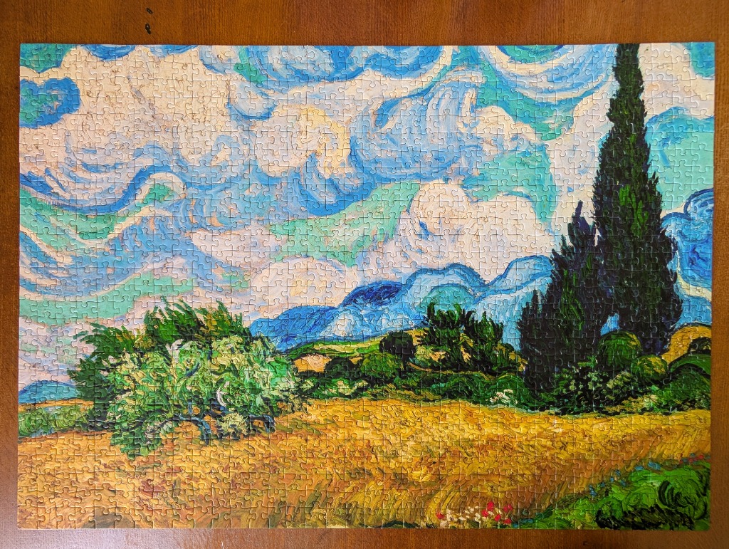 A post-impressionist landscape painting featuring a golden wheat field, swirling sky, and tall dark cypress trees.