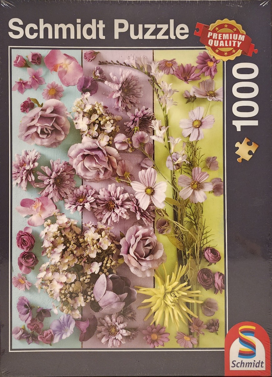 A flat-lay photograph of various purple, pink, and yellow flowers arranged on vertical wooden planks.