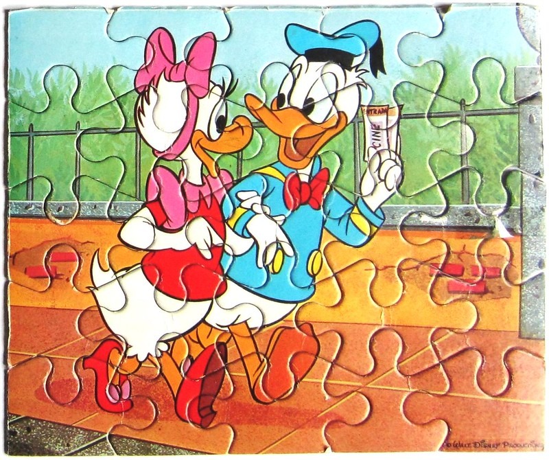 Daisy and Donald Duck walking together carrying a movie ticket