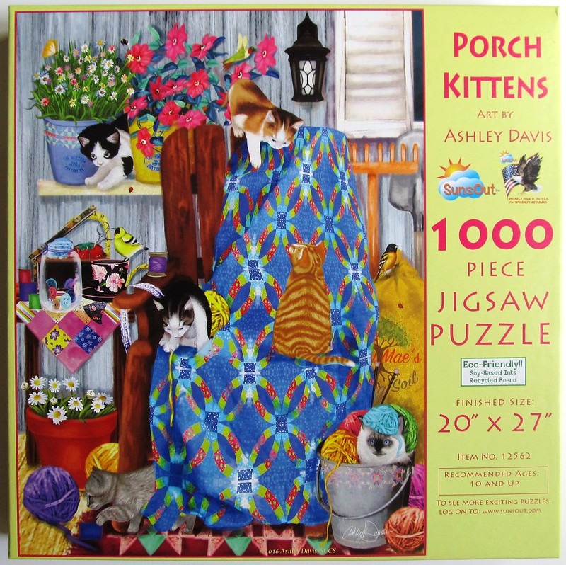 Five kittens playing on a rustic porch with a blue quilt, potted flowers, and craft supplies.
