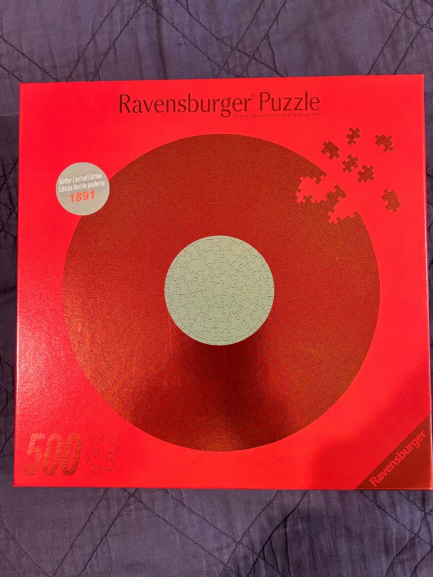 Minimalist design with a large metallic red circular puzzle pattern on a bright red background.