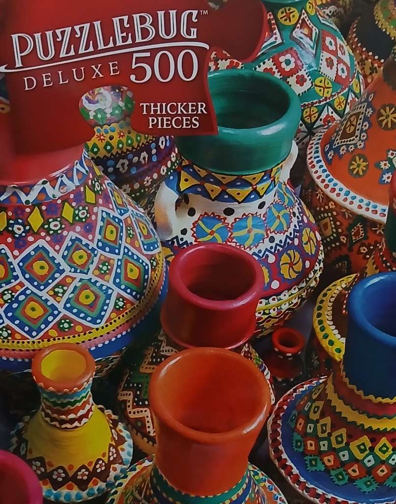 Close-up of vibrant, hand-painted ceramic vases and pottery featuring intricate geometric folk patterns.