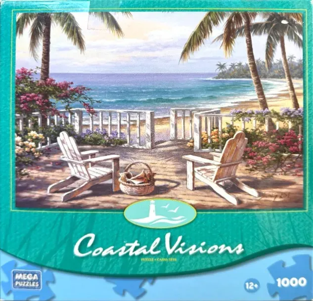 Two white Adirondack chairs on a wooden deck overlooking a tropical ocean beach with palm trees and flowers.