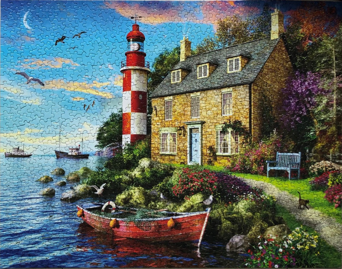A lighthouse and stone cottage sit on a rocky shore by a lake, with a small boat in the foreground at dusk.