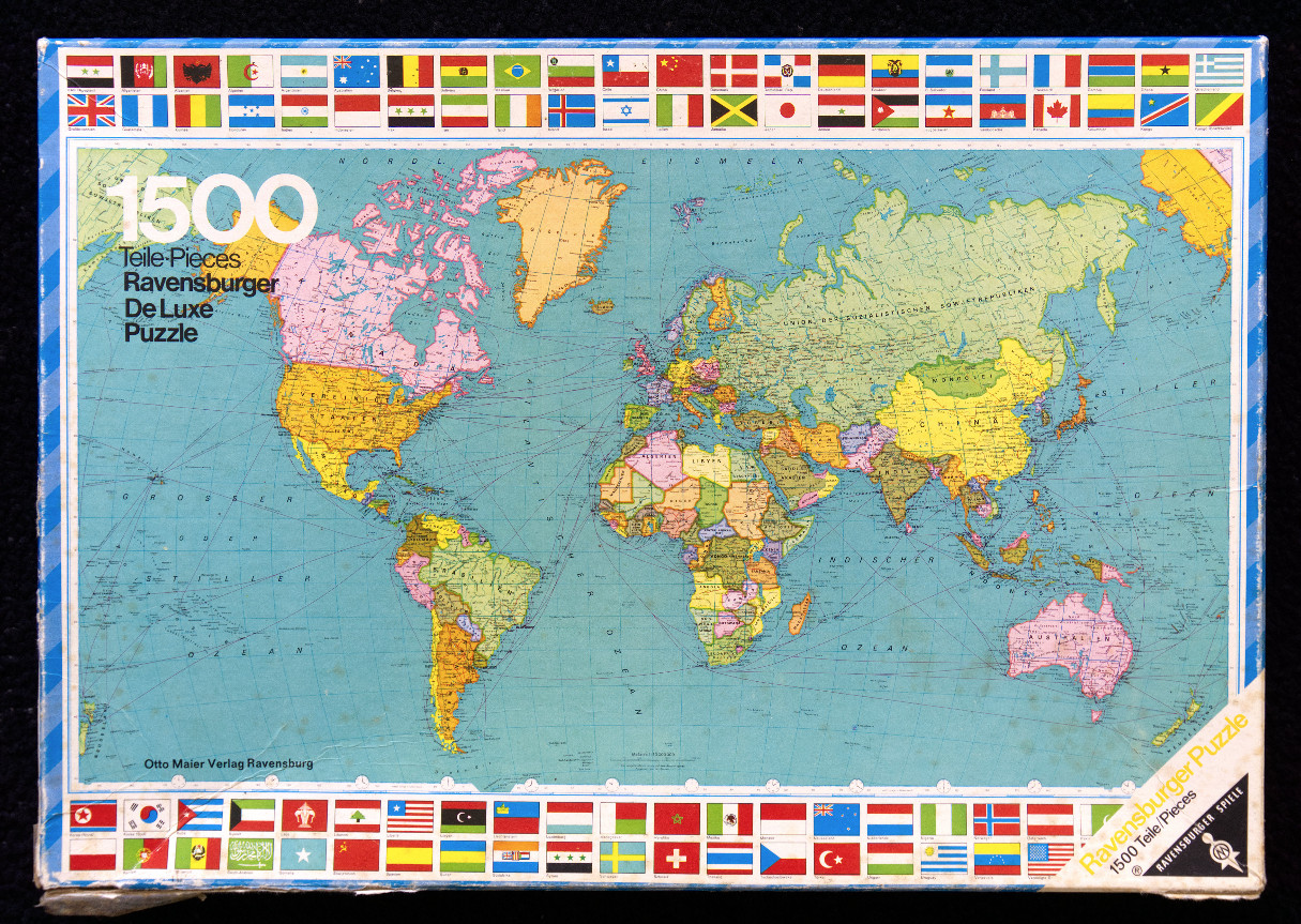 A vintage political world map surrounded by a border of international flags.