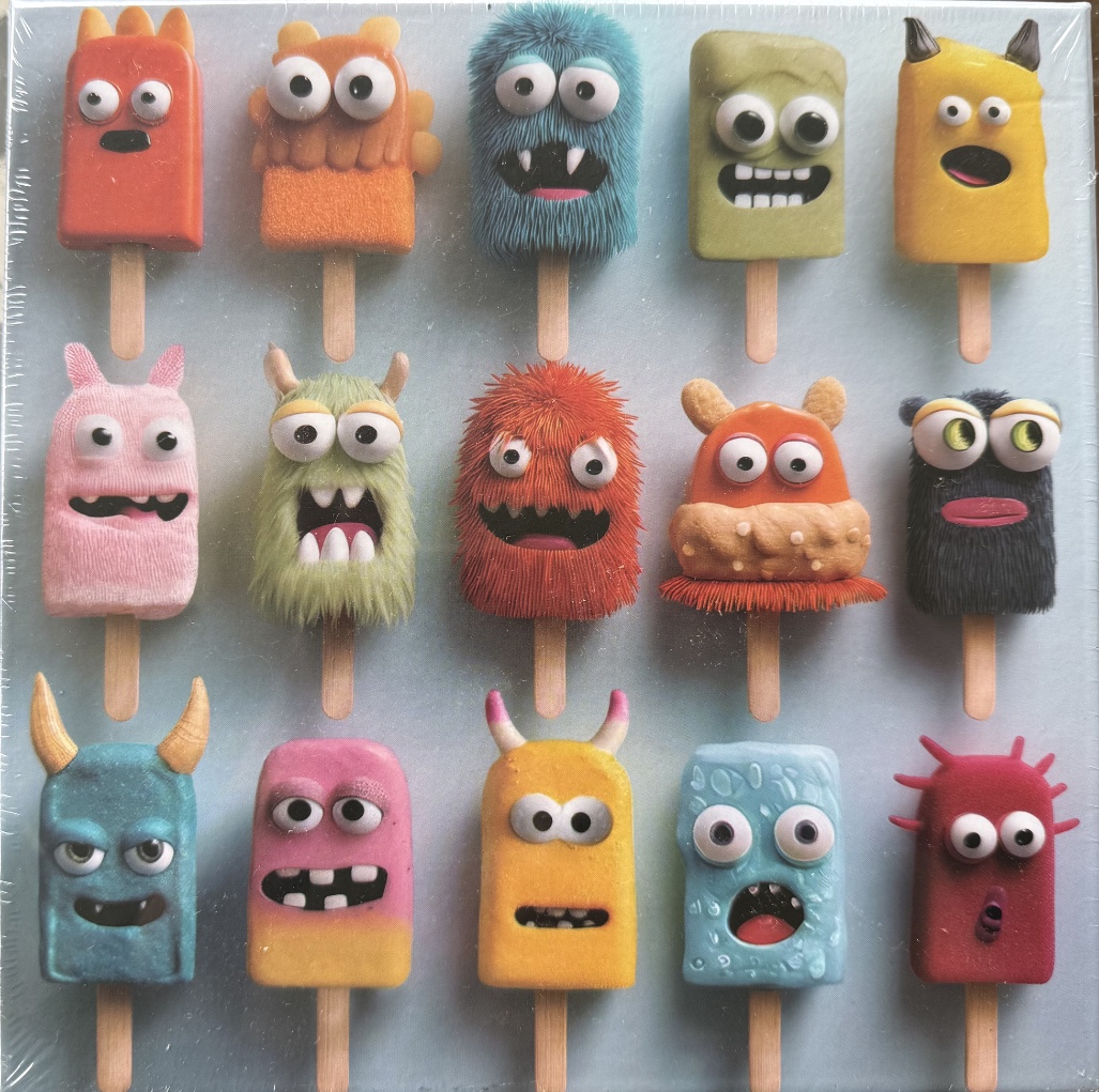 A grid of fifteen whimsical monster-shaped popsicles against a pale blue background.