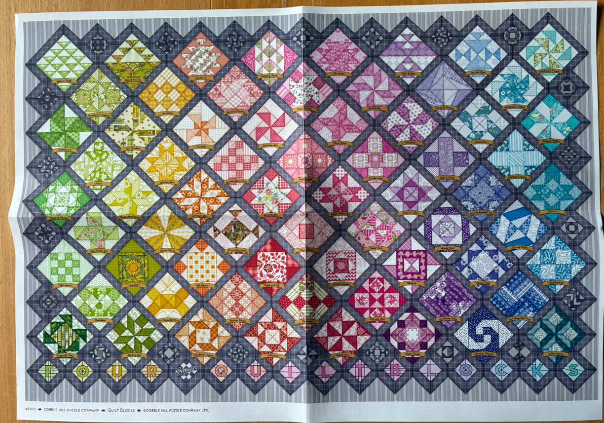 A colorful grid of various quilt block patterns arranged in a rainbow spectrum.