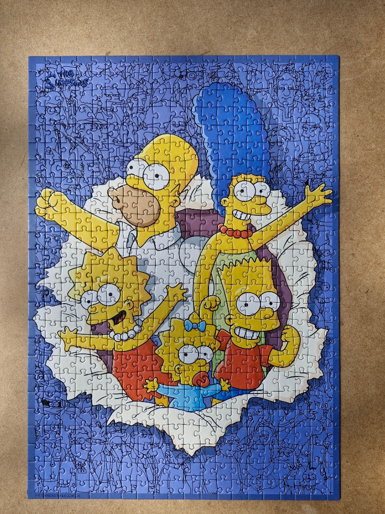 The Simpson family bursting through a blue, sketch-covered background.