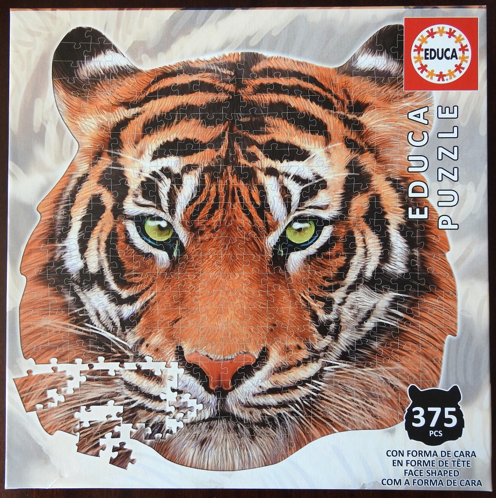 Close-up portrait of a tiger with bright green eyes and orange and black striped fur.