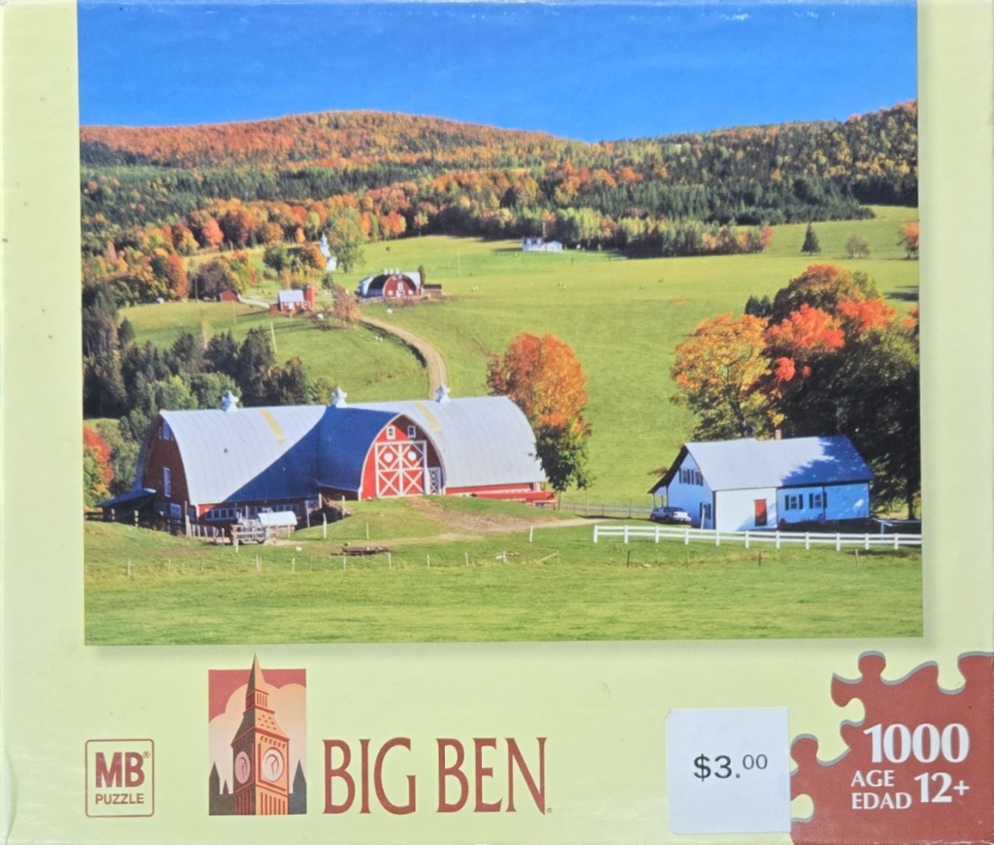 A rural landscape featuring a large red barn and a farmhouse set in a vibrant autumn hillside.