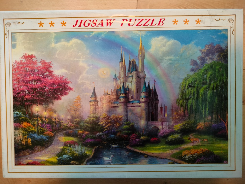 A fairytale castle with blue turrets surrounded by a lush garden, a pond, and a rainbow.