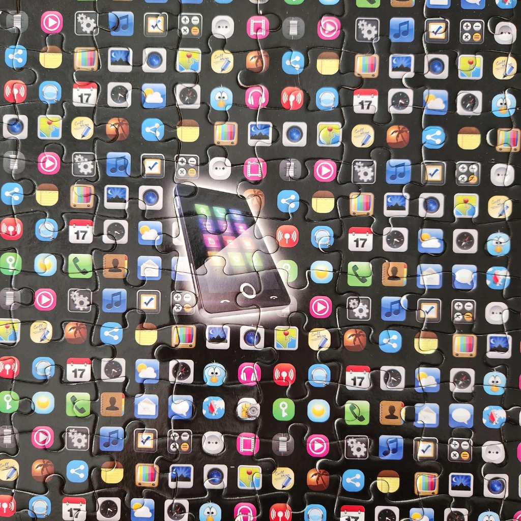 Smartphone at the center surrounded by a grid of colorful mobile application icons on a black background.