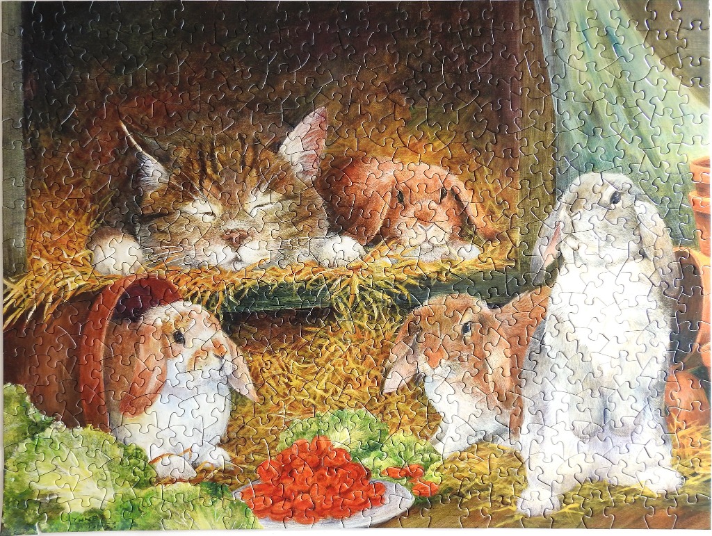 A tabby cat sleeping with three lop-eared rabbits in a cozy barn setting