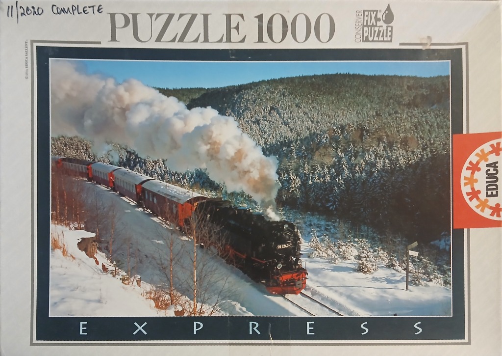 A steam train traveling through a snow-covered mountain landscape