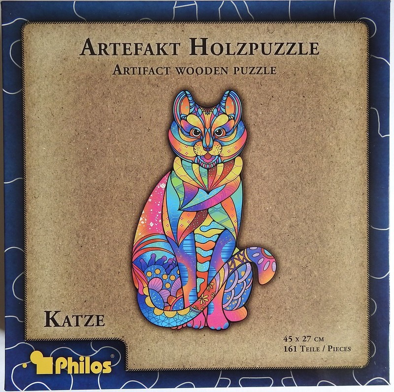 A brightly colored, abstract illustration of a seated cat with complex patterns against a neutral textured background.