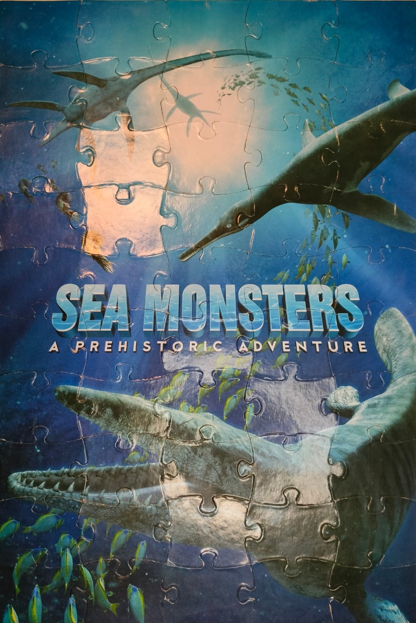 Prehistoric marine reptiles swimming in deep blue water under sunlight