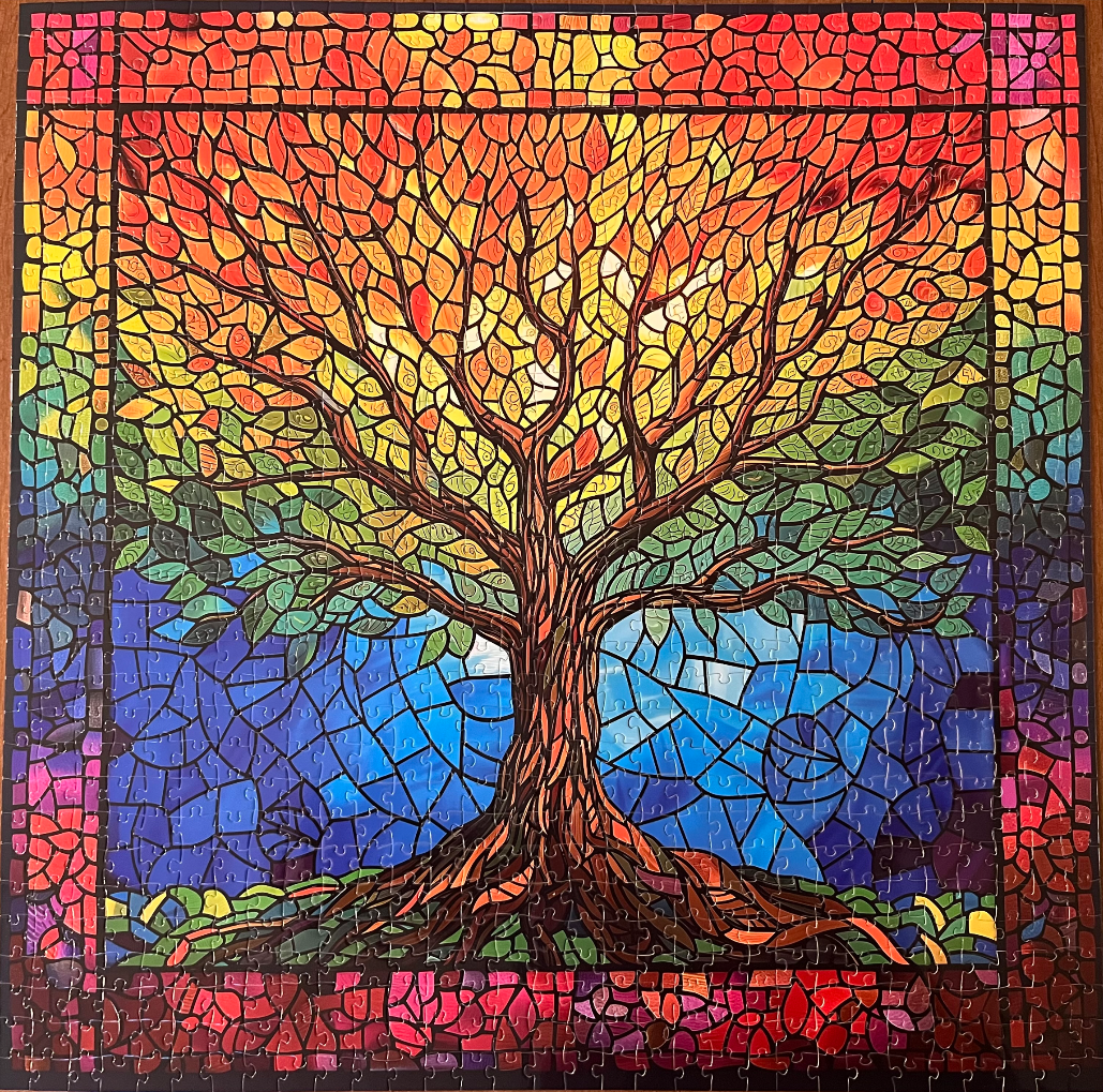 A stained-glass style image of a tree with rainbow-colored leaves and a deep blue background.