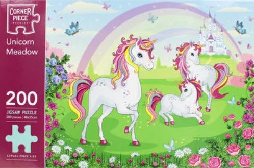 Three white unicorns with colorful manes in a bright green meadow with a castle and rainbow in the background.