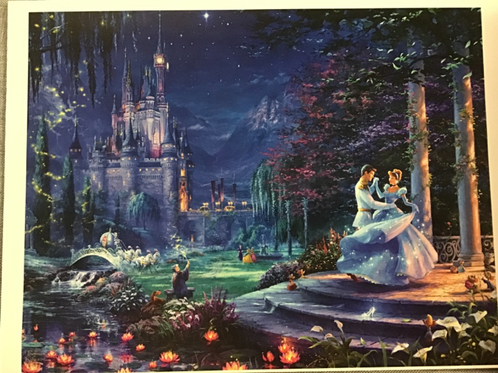 A prince and princess dancing in a magical garden before a castle at night.