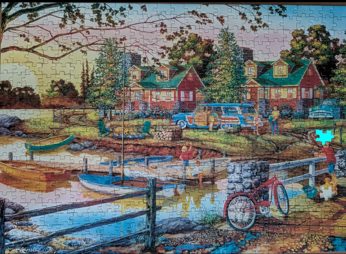 A nostalgic lakeside scene at sunset with cottages, boats, a station wagon, and a boy fishing.