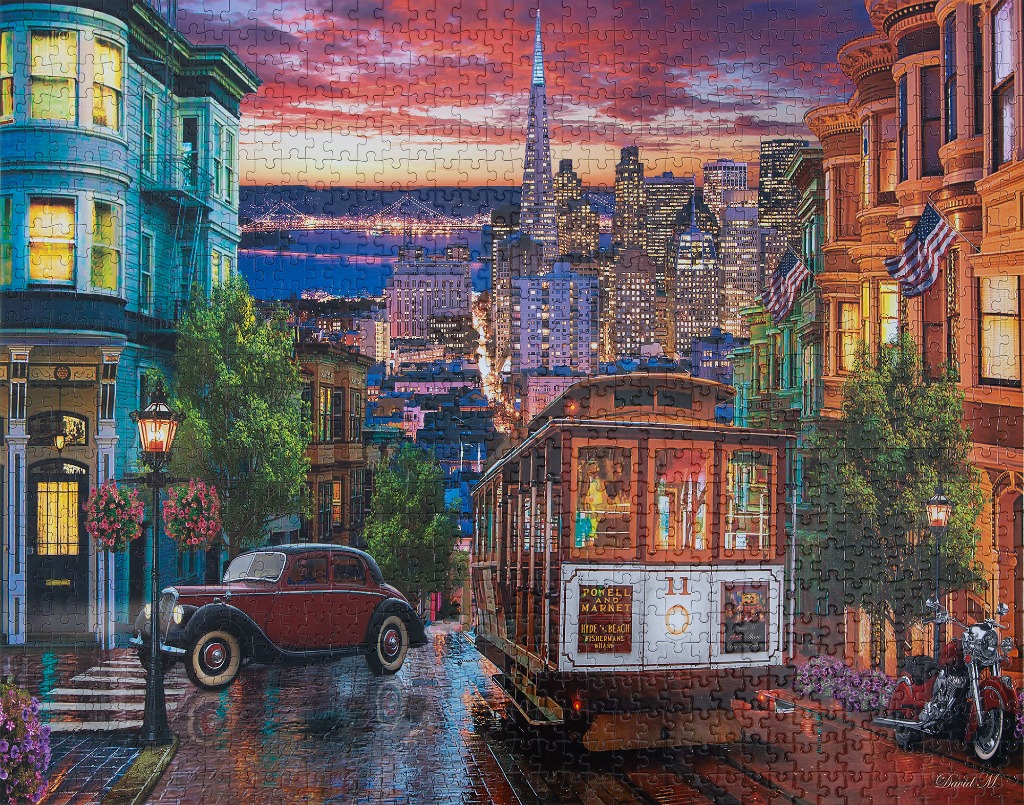 San Francisco street scene with a cable car, vintage car, and the skyline at sunset.