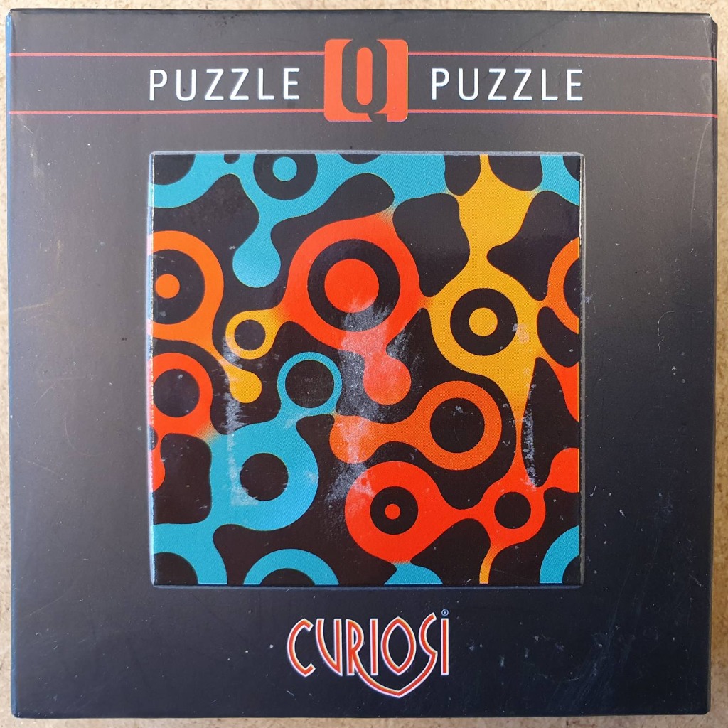 Abstract graphic pattern of interlocking, organic cell-like shapes in bright orange, yellow, and turquoise on black.