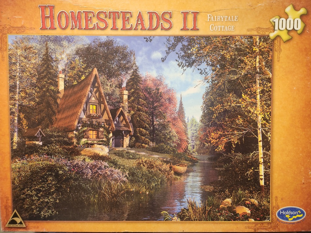 A fairytale cottage with a thatched roof situated by a river in an autumnal forest.