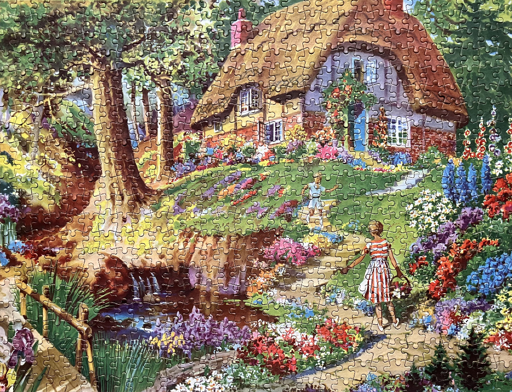 A charming thatched-roof cottage in a vibrant English garden with a stream and a woman walking along a stone path.