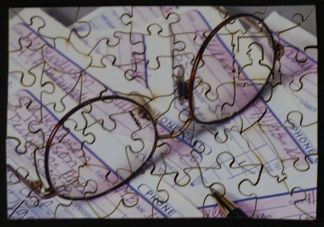 A pair of tortoiseshell glasses resting on top of a stack of vintage telephone message pads.