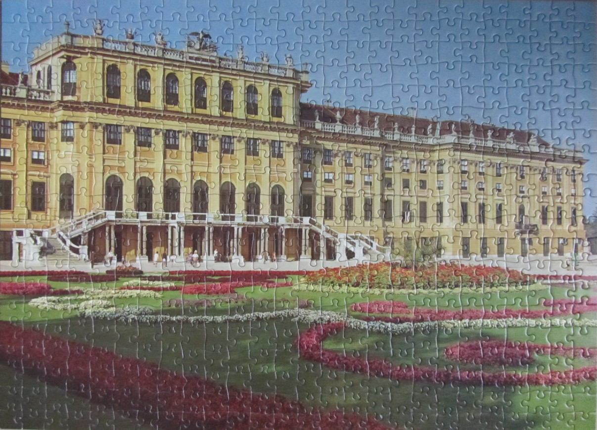 Schonbrunn Palace exterior facade with elaborate formal garden in the foreground