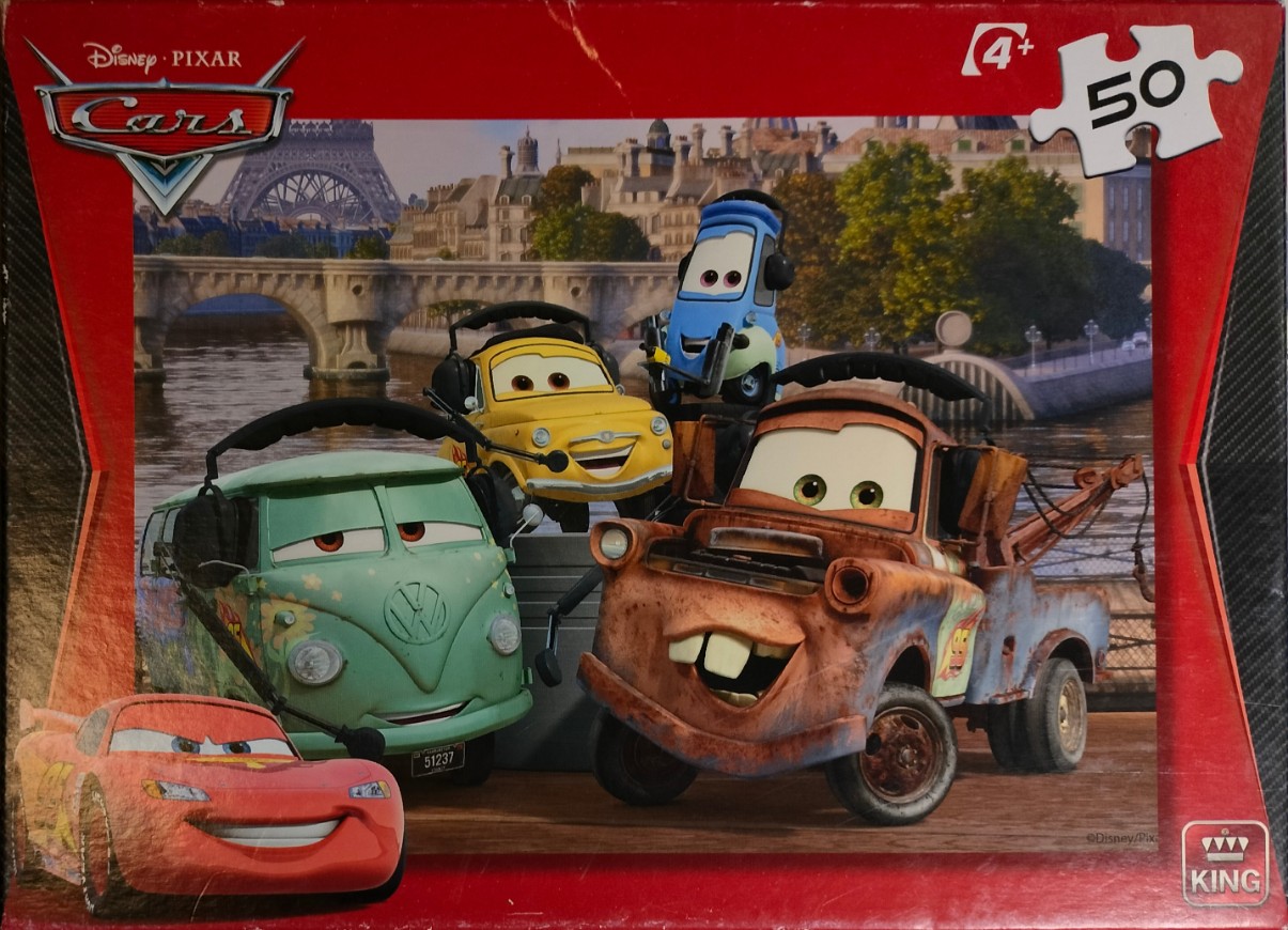 Animated characters from Cars posed in front of the Eiffel Tower in Paris.