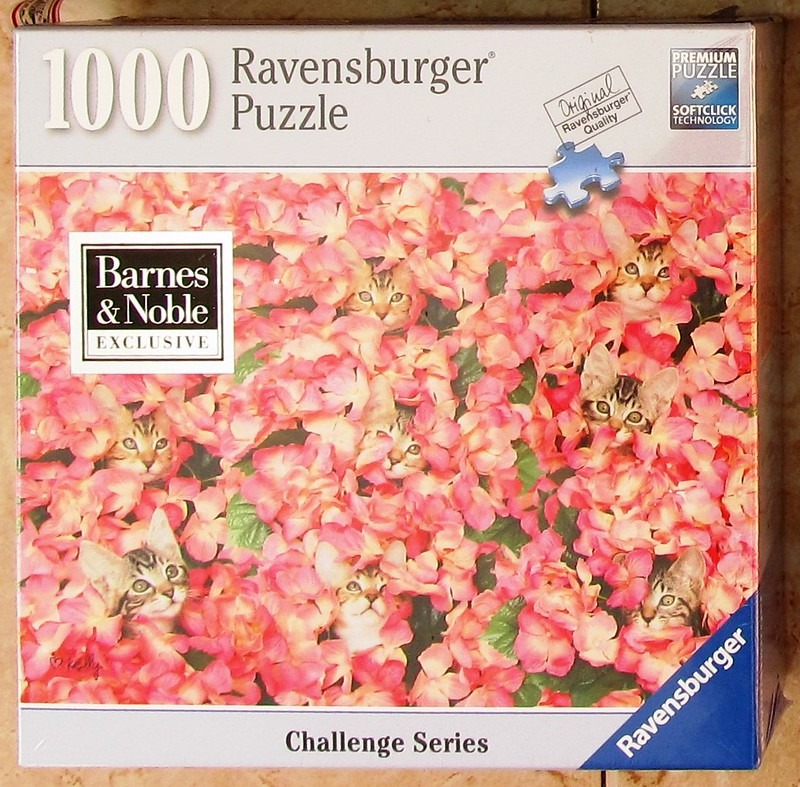 Several tabby kittens peeking through a dense field of pink hydrangea blossoms.