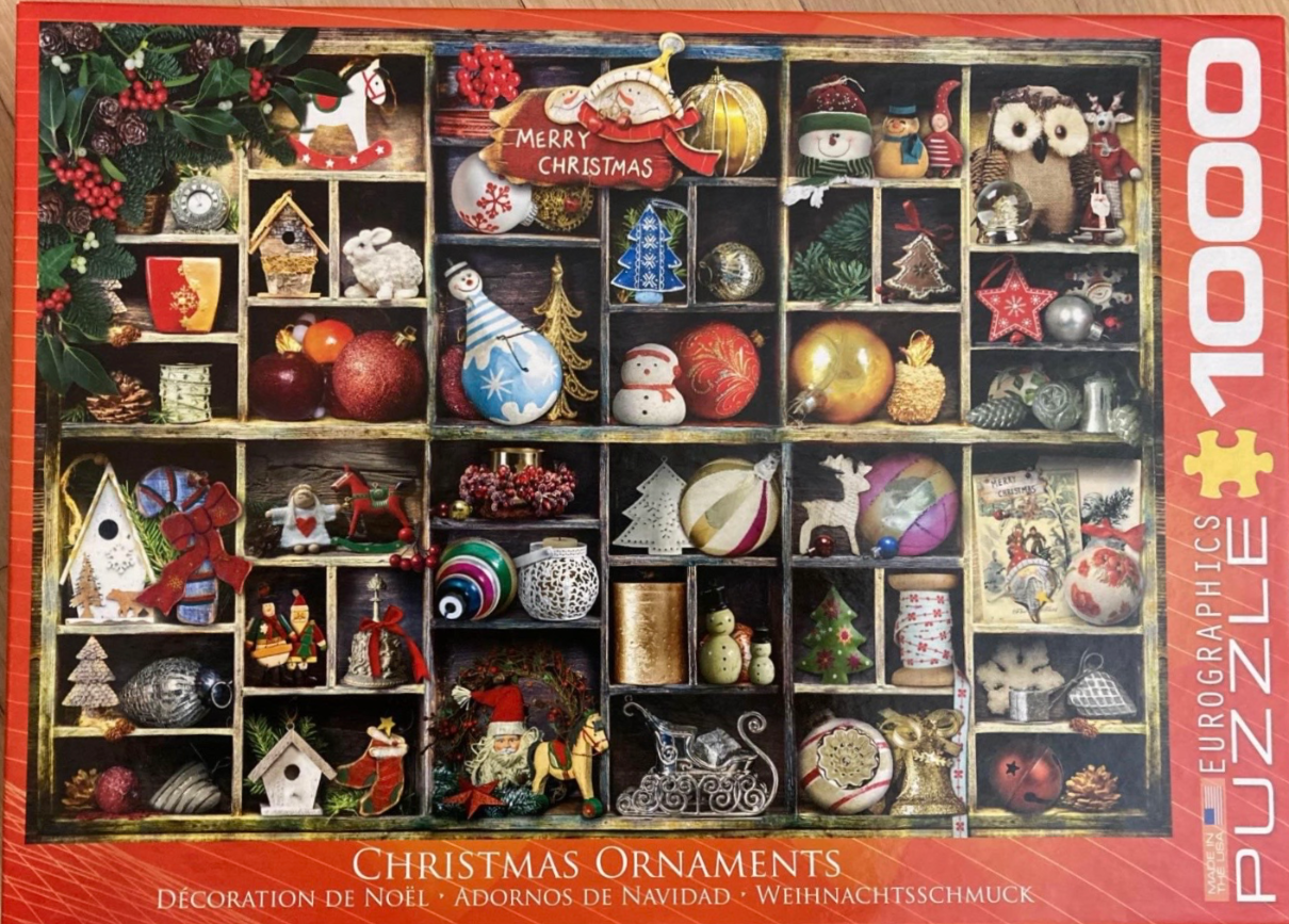 A wooden printer's tray filled with various vintage-style Christmas ornaments and decorations.