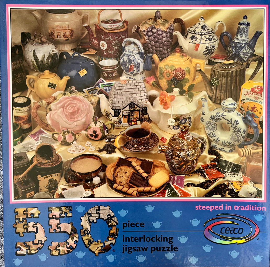 A collection of decorative teapots, tea cups, and biscuits arranged on a golden satin cloth.