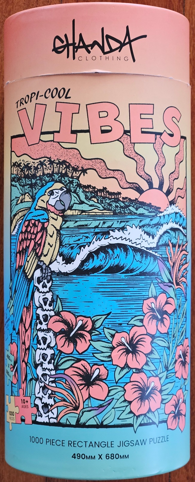 A retro-style illustration featuring a colorful macaw perched on a totem of skulls overlooking a tropical beach.