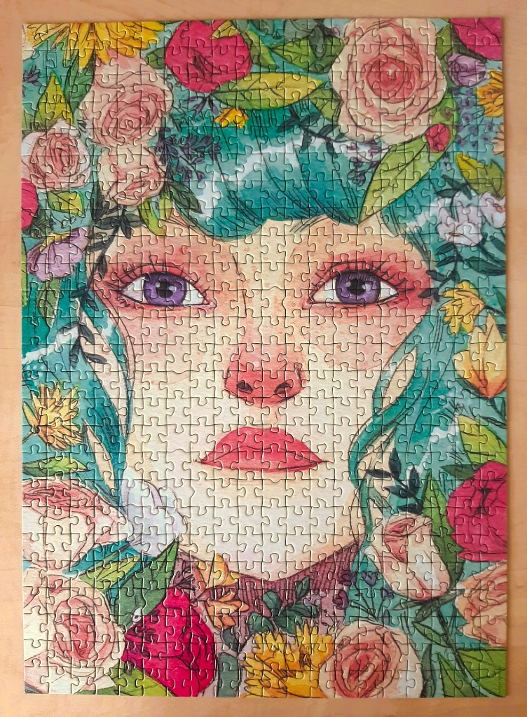 Watercolor illustration of a woman's face surrounded by colorful flowers and teal foliage.