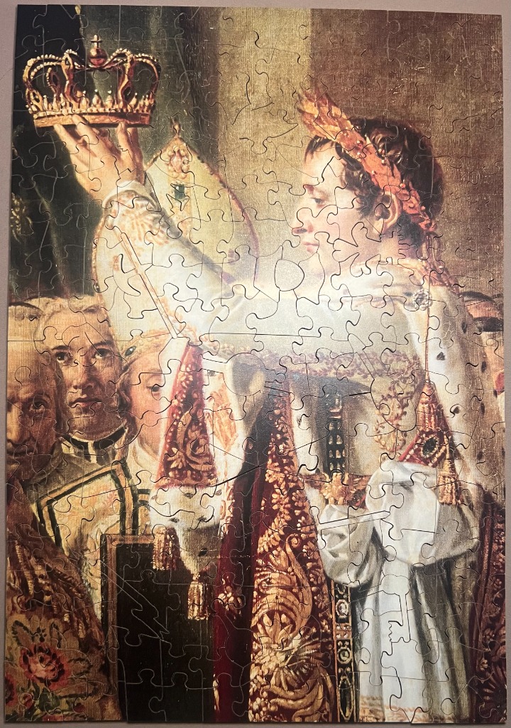 An oil painting depiction of Napoleon Bonaparte holding a crown above his head during his coronation ceremony.