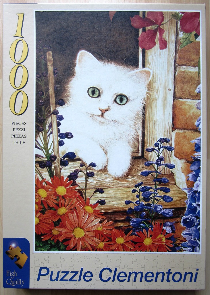 A fluffy white kitten with green eyes peeking out from a window, surrounded by bright orange and purple flowers.