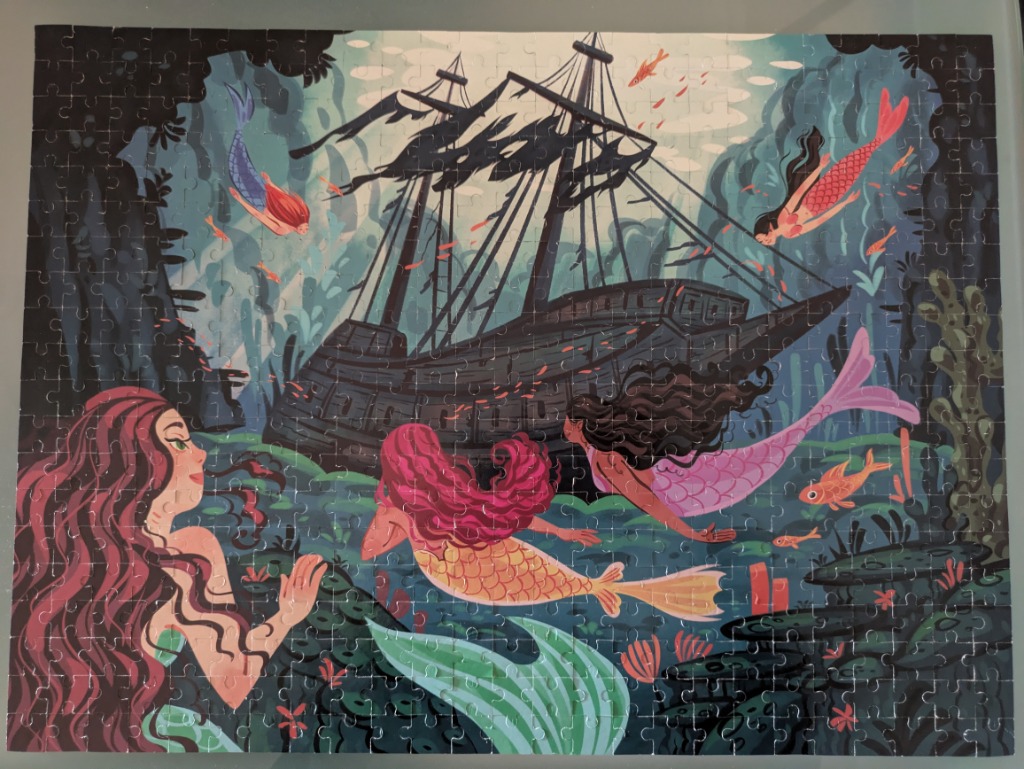 An illustration of four mermaids swimming around a dark, sunken shipwreck in a deep, mysterious ocean.