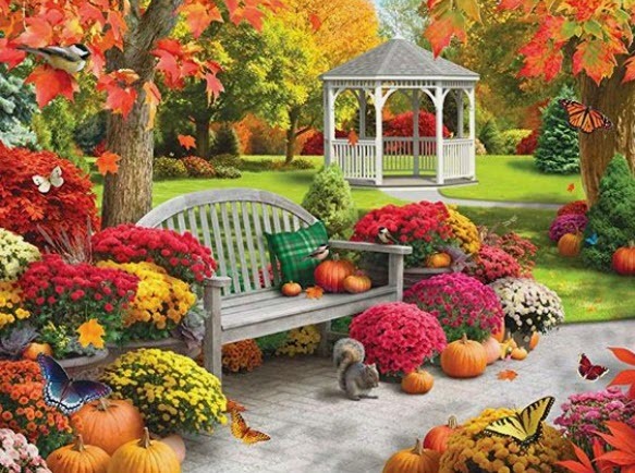 A squirrel on a stone patio in front of a white gazebo surrounded by colorful autumn flowers and pumpkins.