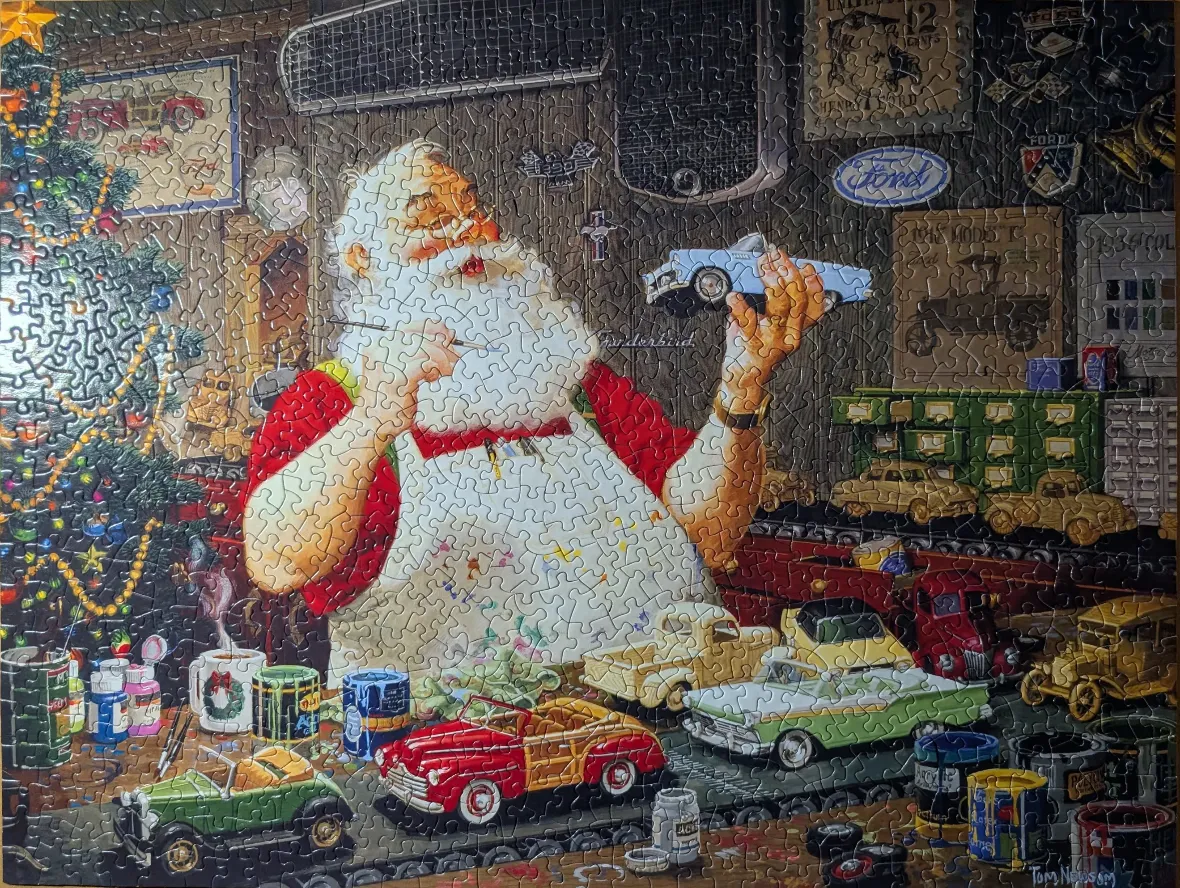 Santa Claus painting toy model cars in a workshop filled with vintage automotive memorabilia.