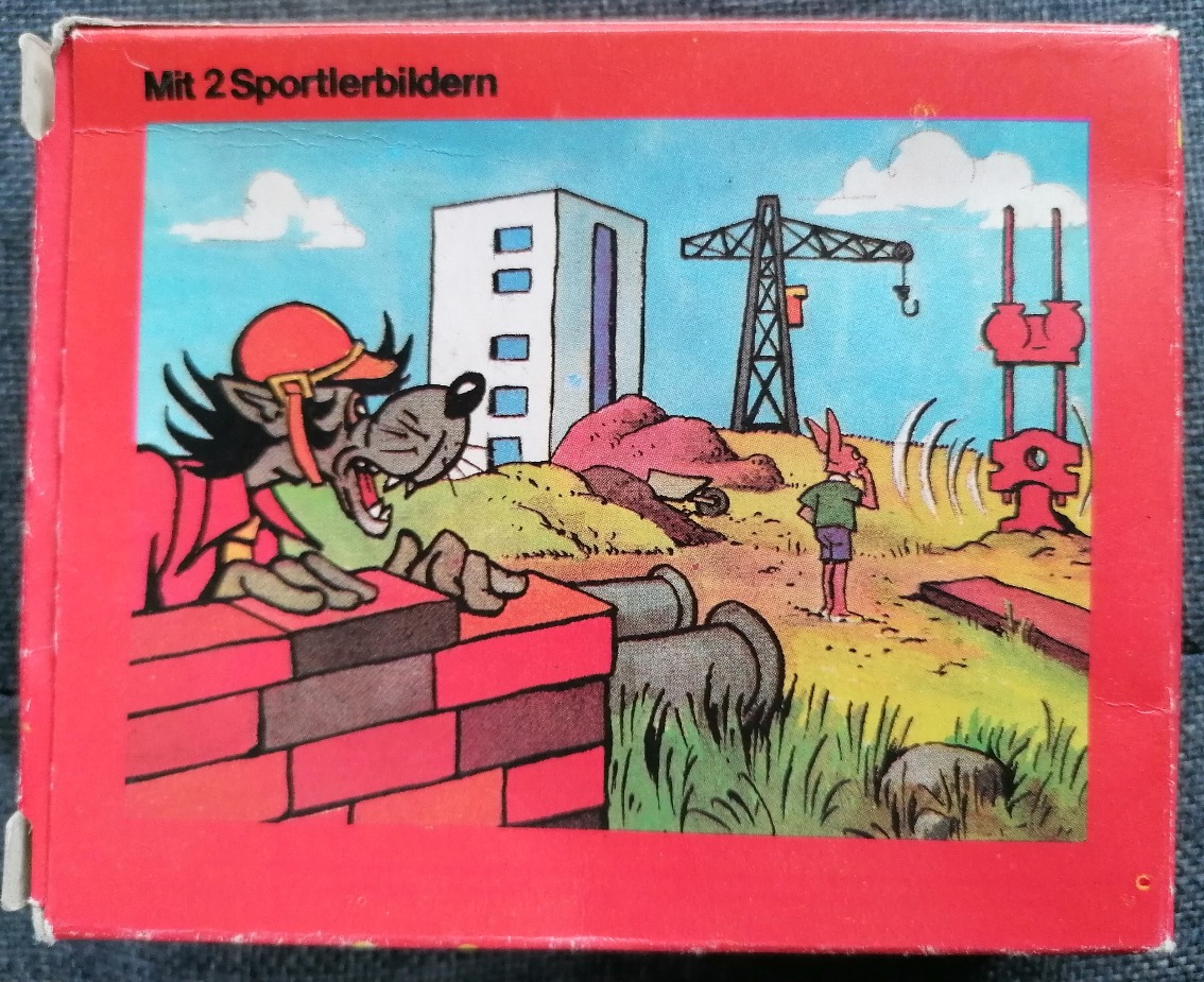Cartoon scene of a wolf peering over a wall at a rabbit on a construction site